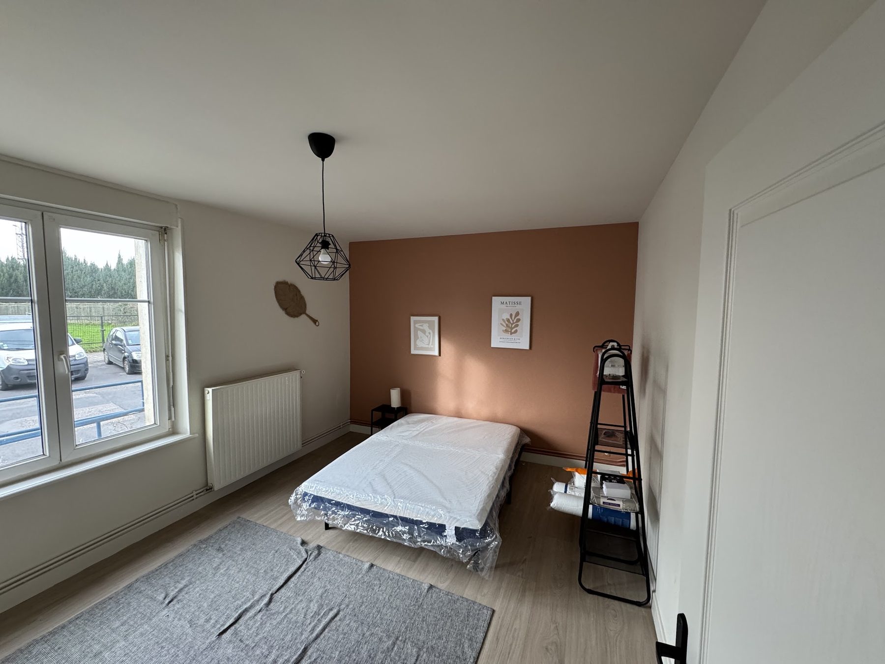 Chambre au mur terracotta, sol chêne clair