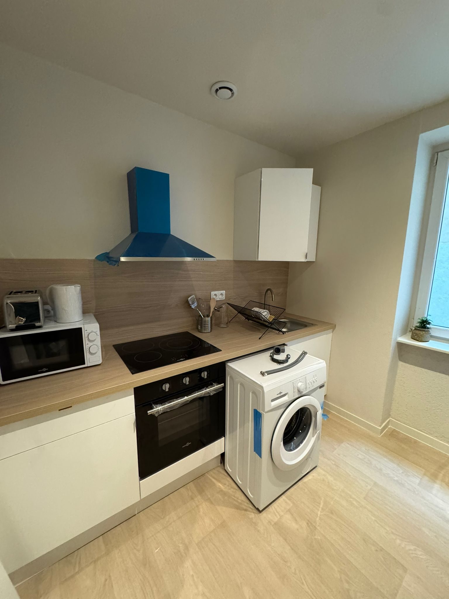 Kitchenette blanche à hotte bleue